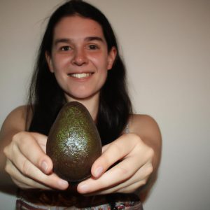 Person holding an avocado, smiling